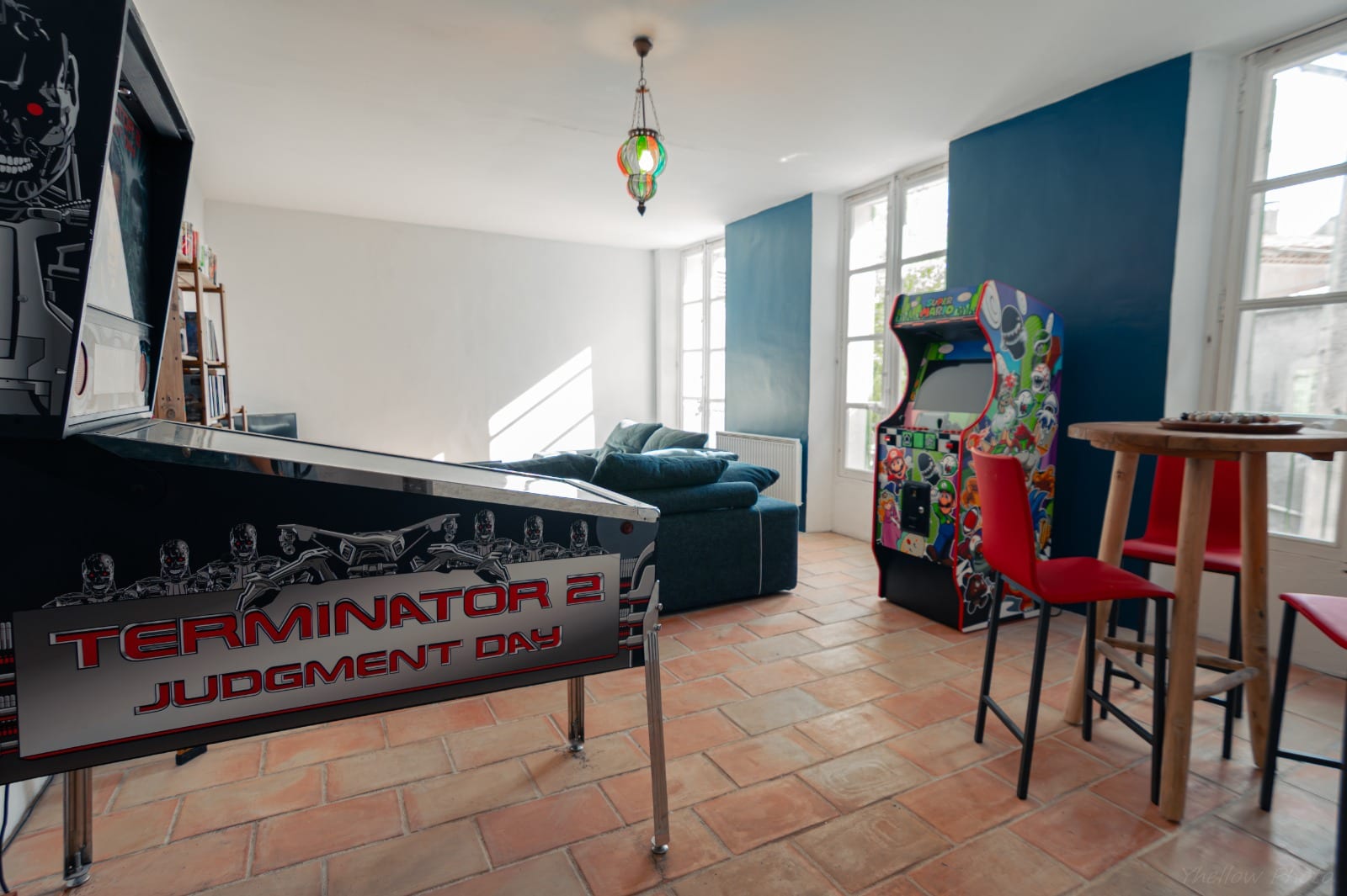 Salle de loisirs avec borne d'arcade et canapé au Couvent des Pallières